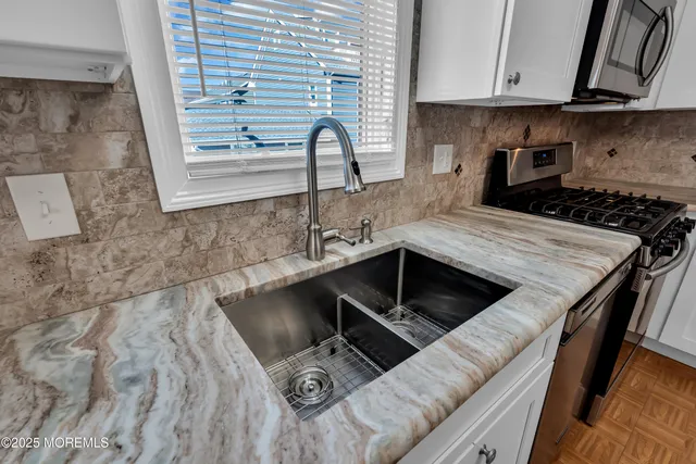 a kitchen with stainless steel appliances granite countertop a refrigerator and a stove top oven