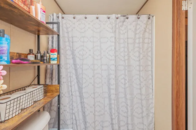 a view of a bathroom with a shower curtain and a sink