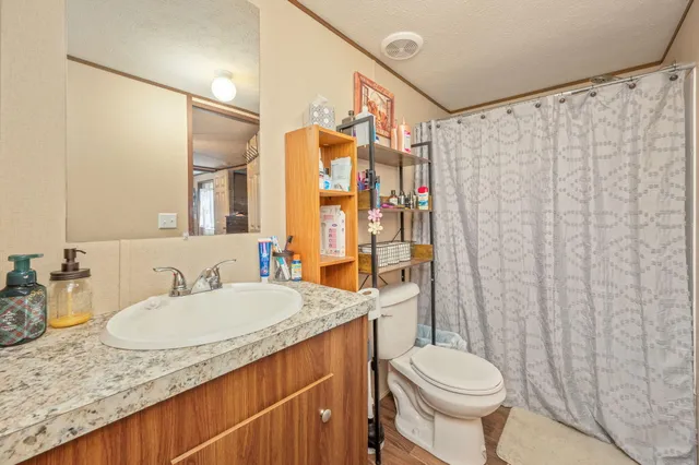 a bathroom with a granite countertop sink toilet and shower