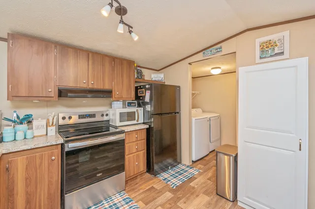 a kitchen with a refrigerator and a stove top oven