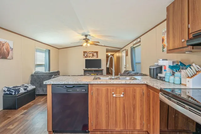 a kitchen with granite countertop a sink stove and cabinets