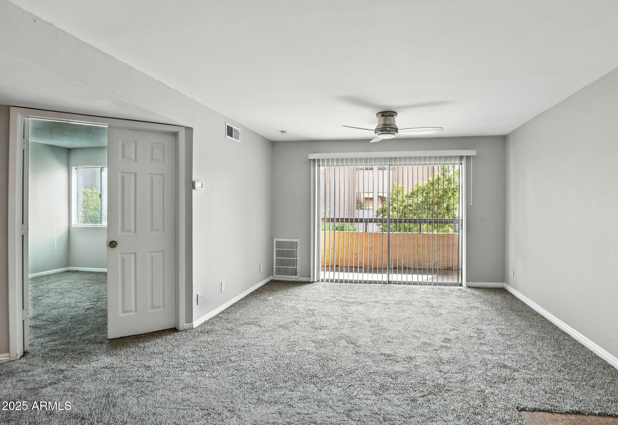 8055 East Thomas Road, Unit N201 Scottsdale, AZ 85251 - Photo 15 of 28 an empty room with large window and a ceiling fan