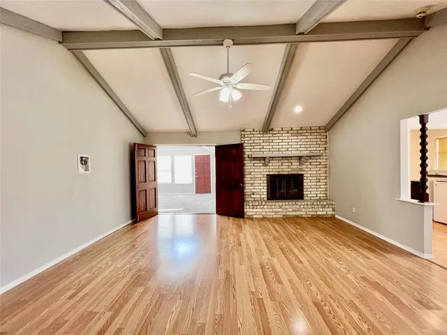 a view of an empty room with a fireplace and a window