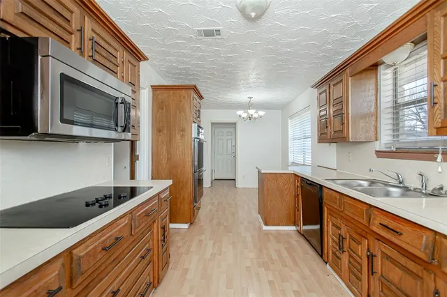 a kitchen with stainless steel appliances granite countertop a sink and cabinets