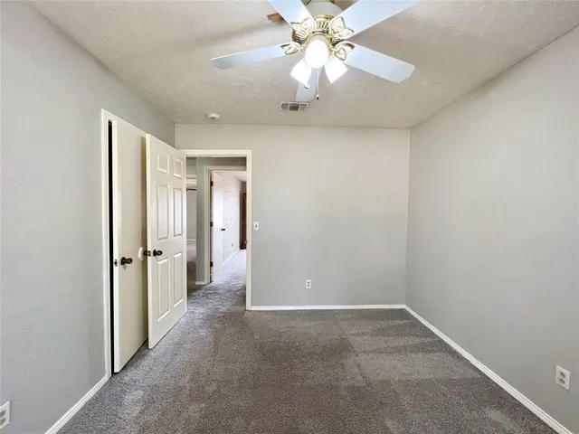 an empty room with fan and entrance
