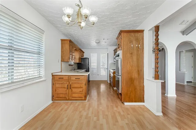 a view of a kitchen with a sink a refrigerator and wooden floor