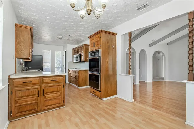 a view of kitchen with stainless steel appliances granite countertop a stove cabinets and wooden floor