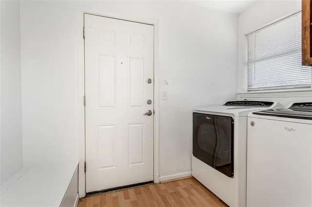 a view of a kitchen with white cabinets and wooden floor