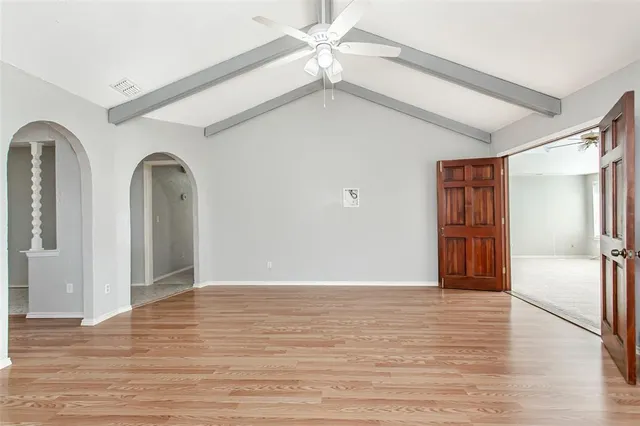 a view of empty room with wooden floor