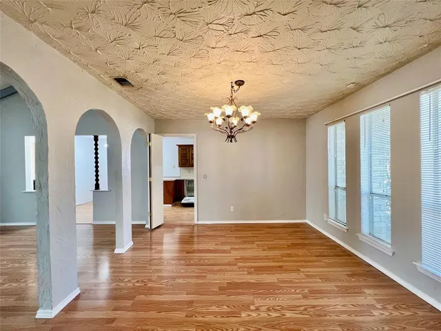 a view of a livingroom with a chandelier fan and wooden floor