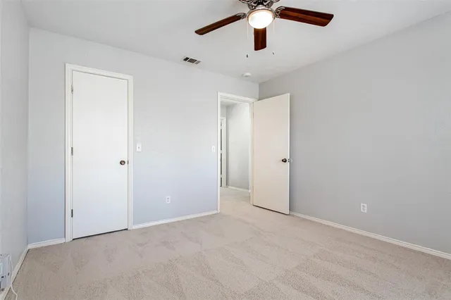 an empty room with a ceiling fan and a window