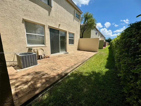 a view of backyard with large windows and plants