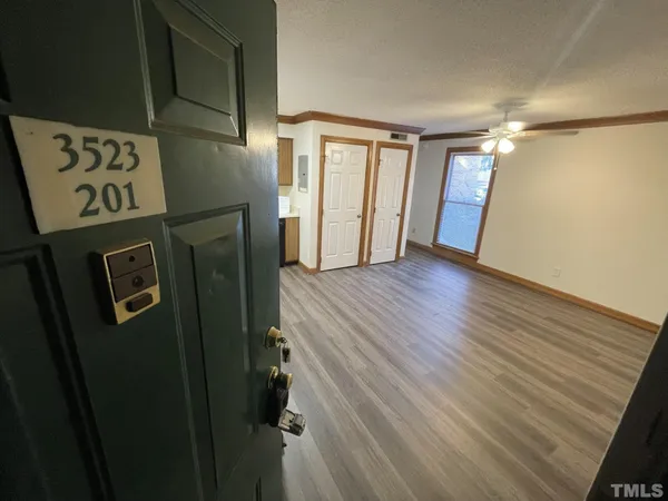 a view of a hallway with wooden floor and entryway