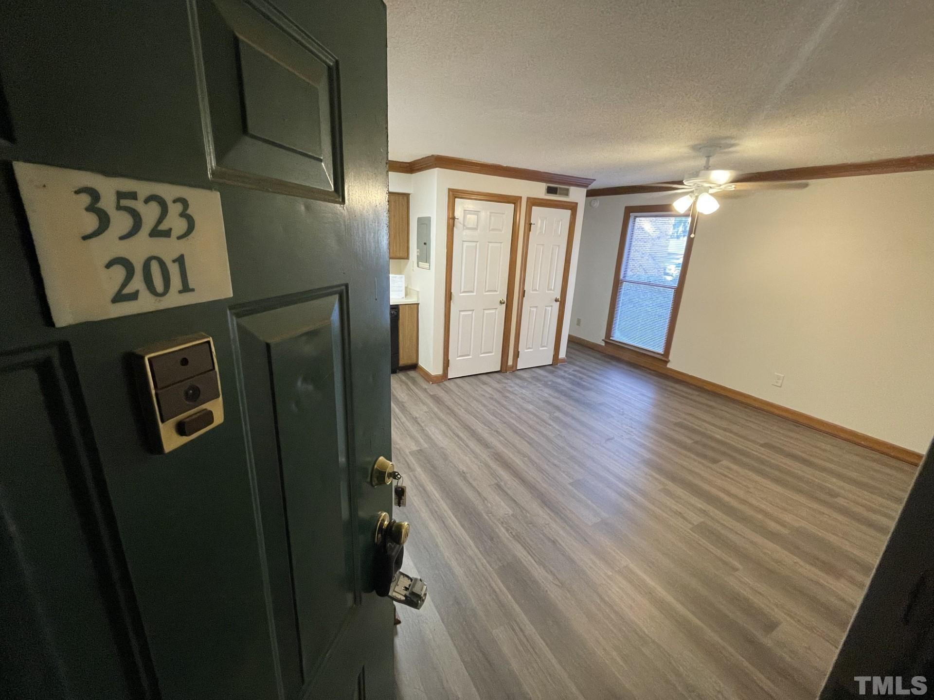 a view of a hallway with wooden floor and entryway