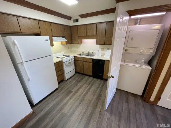 a kitchen with a refrigerator a stove top oven and wooden floor