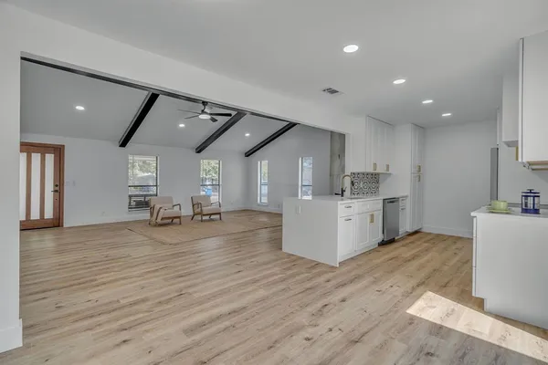 a large white kitchen with lots of counter space and a sink