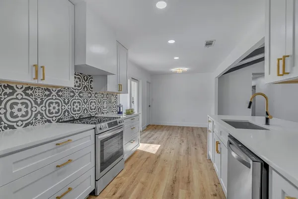 a kitchen with granite countertop a stove and a sink
