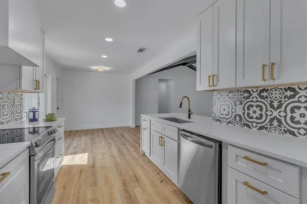 a kitchen with stainless steel appliances granite countertop a sink stove and cabinets