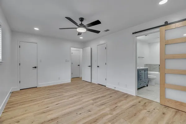 a view of empty room with wooden floor and ceiling fan