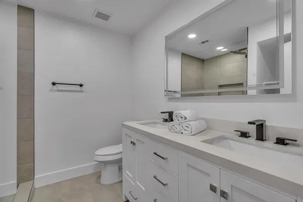 a bathroom with a toilet sink and mirror