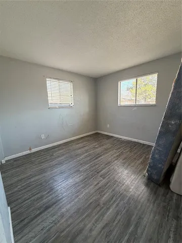 a view of a room with wooden floor and a window