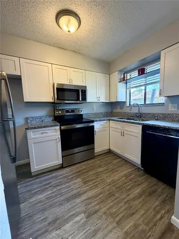 a kitchen with stainless steel appliances granite countertop a stove a sink and a microwave