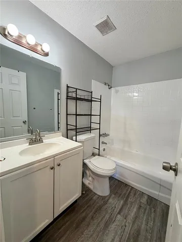 a bathroom with a toilet sink a mirror a bathtub and shower