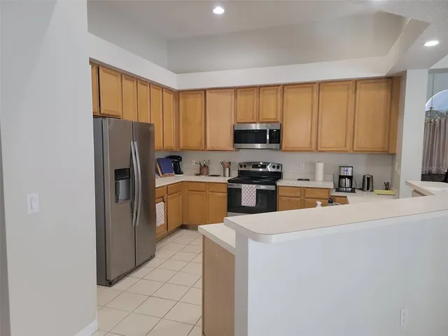 a kitchen with stainless steel appliances a refrigerator sink and microwave