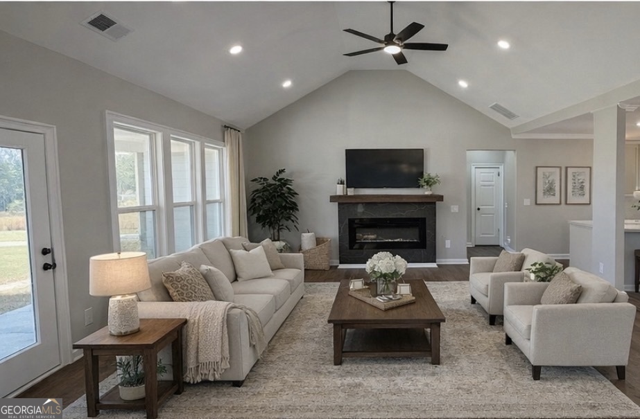 1205 Rocky Creek Road Hampton, GA 30228 - Photo 17 of 55 a living room with furniture a fireplace and a flat screen tv