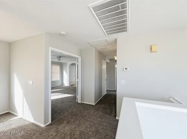 a view of a hallway to rooms