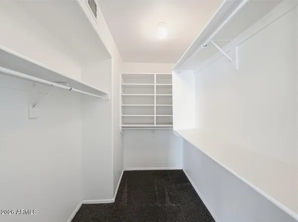 a view of walk in closet with empty racks