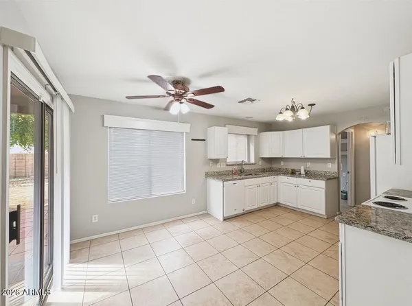 a large kitchen with a window and stainless steel appliances