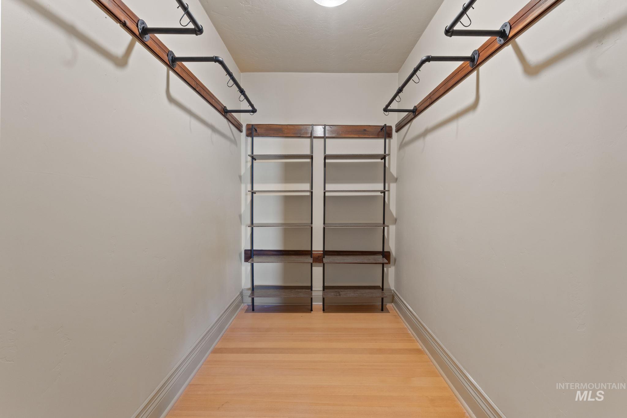 424 West Main Street Weiser, ID 83672 - Photo 16 of 30 Walk-in closet featuring light wood-finish flooring, white walls, built-in shelving units, and industrial-style clothing rods