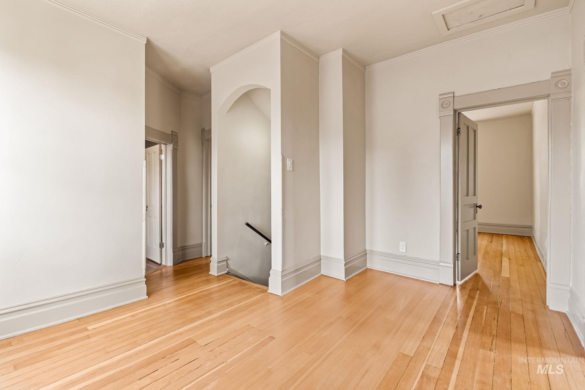 424 West Main Street Weiser, ID 83672 - Photo 17 of 30 Hardwood flooring throughout featuring an arched doorway and a paneled door with decorative trim