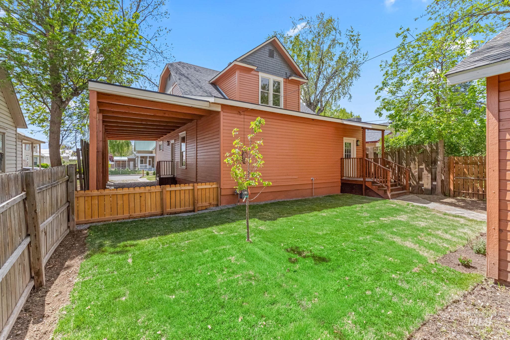 424 West Main Street Weiser, ID 83672 - Photo 30 of 30 Expansive green lawn with a young tree, bordered by a wooden fence