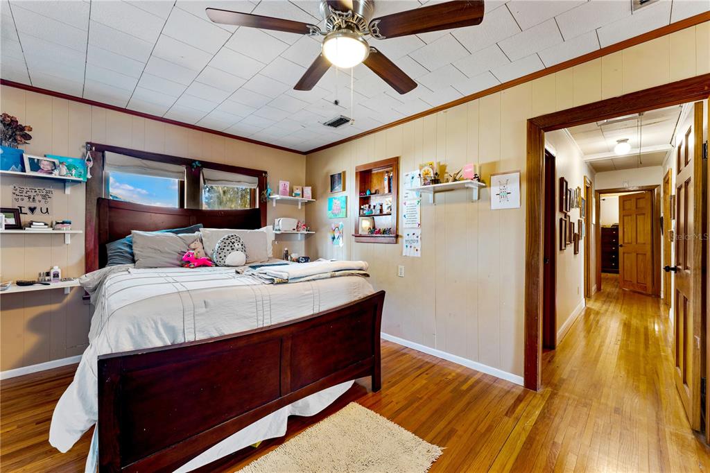 9504 Fort King Road Dade City, FL 33525 - Photo 22 of 51 a bedroom with a bed and a chandelier