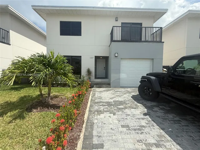 a row of potted plants in front of a house