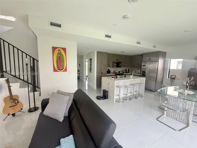 a living room with furniture and kitchen view