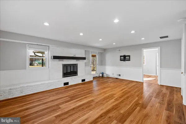 a view of empty room with wooden floor and fireplace