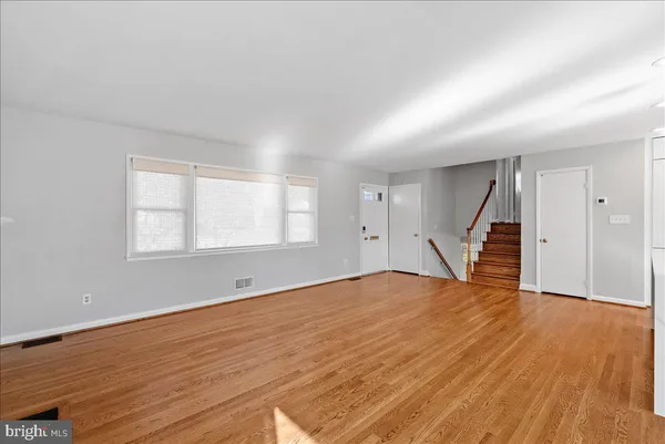 a view of empty room with wooden floor and window