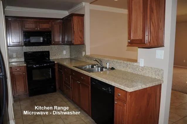 a kitchen with stainless steel appliances granite countertop a sink stove and microwave