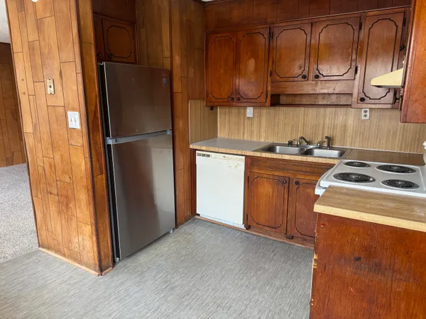 a kitchen with a refrigerator sink and cabinets
