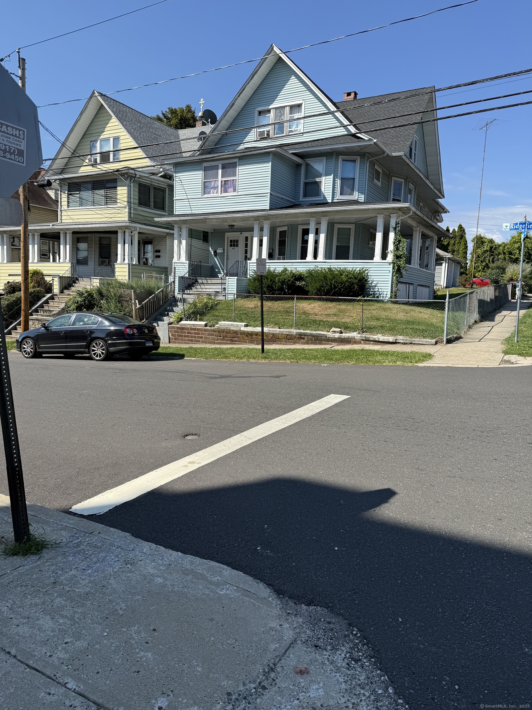 a front view of a residential apartment building with a yard and potted plants