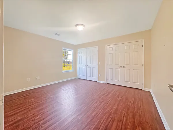 a view of an empty room with wooden floor