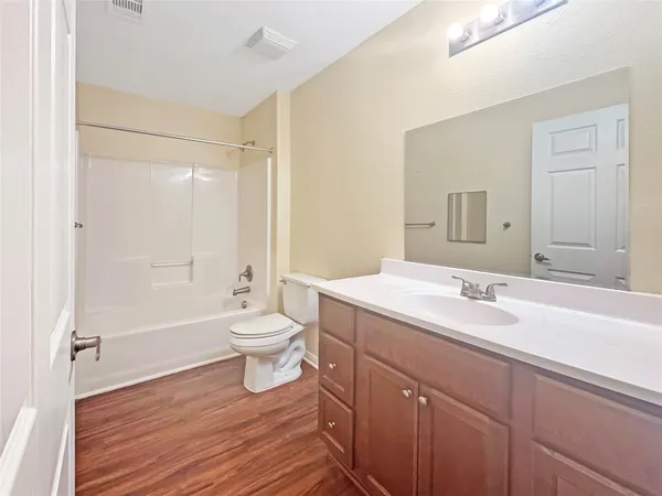 a bathroom with a granite countertop sink toilet a large mirror a shower and bathtub