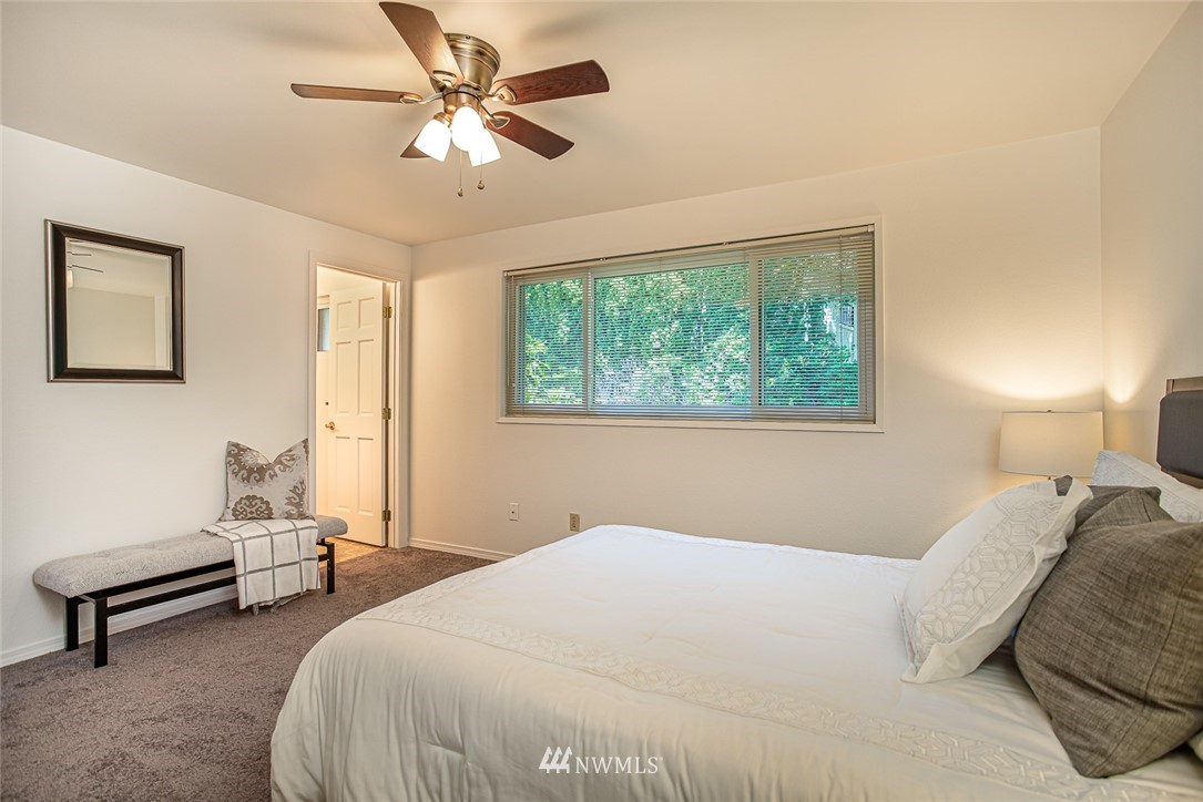12740 Southeast 190th Place Renton, WA 98058 - Photo 11 of 28 a bedroom with a bed a couch and a chandelier
