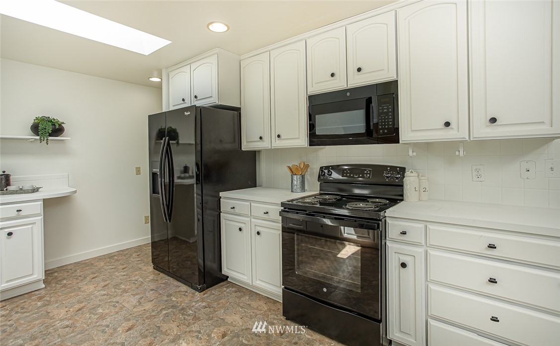 12740 Southeast 190th Place Renton, WA 98058 - Photo 6 of 28 a kitchen with stainless steel appliances white cabinets and a stove top oven