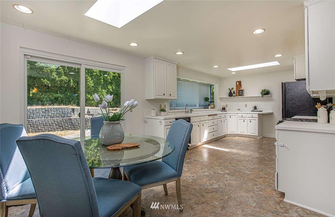 12740 Southeast 190th Place Renton, WA 98058 - Photo 8 of 28 a kitchen with kitchen island a stove a table and chairs
