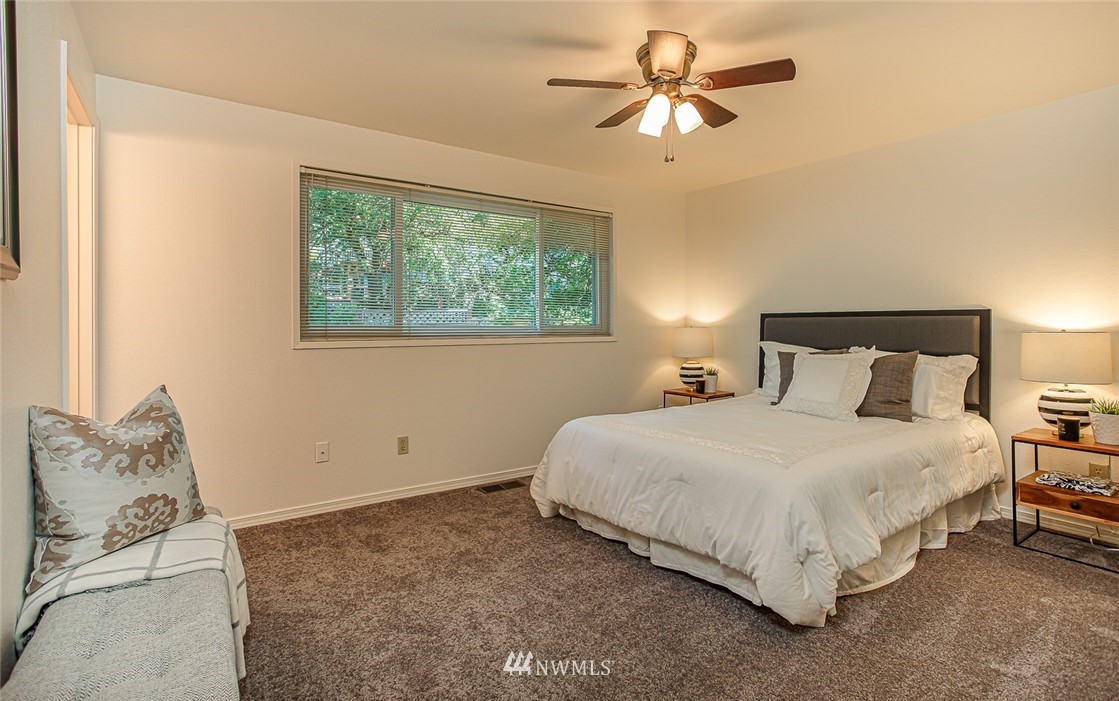 12740 Southeast 190th Place Renton, WA 98058 - Photo 10 of 28 a bedroom with a bed chandelier and a window
