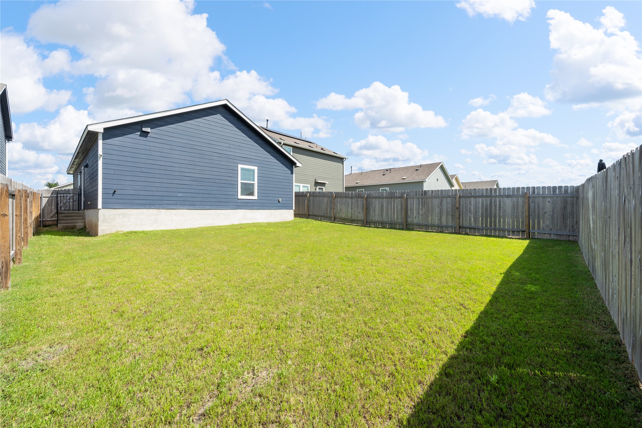 14404 Berning Road Manor, TX 78653 - Photo 37 of 38 A spacious backyard with mature fencing, offering privacy and a verdant expanse for outdoor enjoyment.